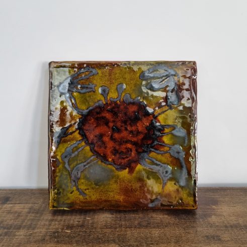 glazed earthenware tile with slip decoration featuring a crab by Clive Bowen