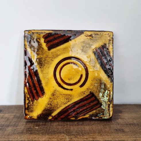 glazed earthenware tile with slip decoration featuring circle design by Clive Bowen