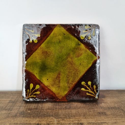glazed earthenware tile with slip decoration featuring square design by Clive Bowen