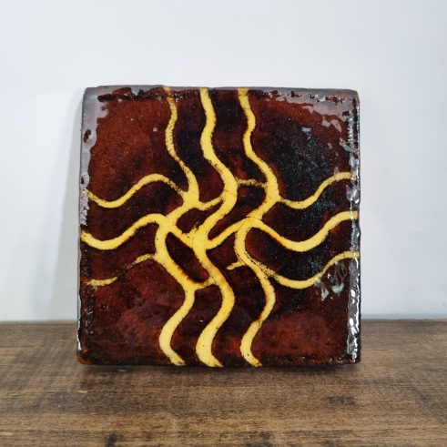 glazed earthenware tile with slip decoration featuring a wave design by Clive Bowen