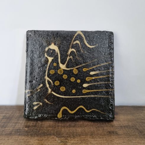 glazed earthenware tile with slip decoration featuring a bird by Clive Bowen