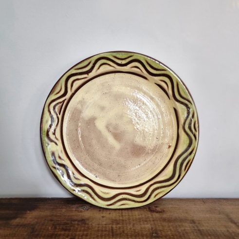 glazed earthenware round plate with slip decoration