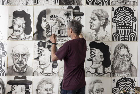Stephen Bird in front of a wall of drawings